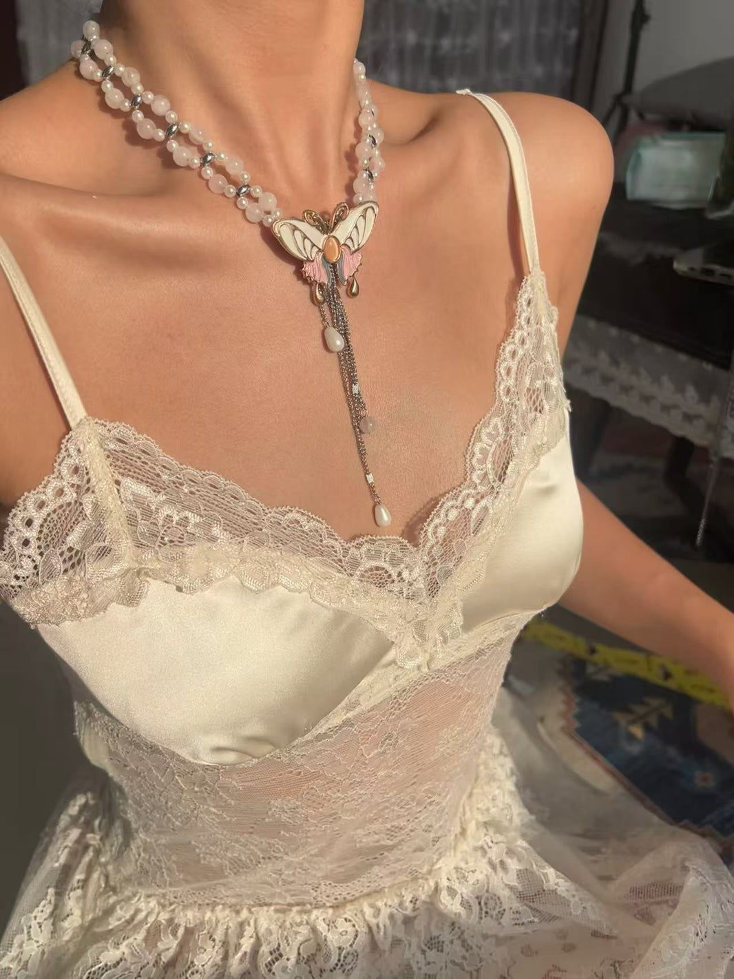 Double strand pearl rose quartz choker with enamel pastel butterfly on lace cami dress