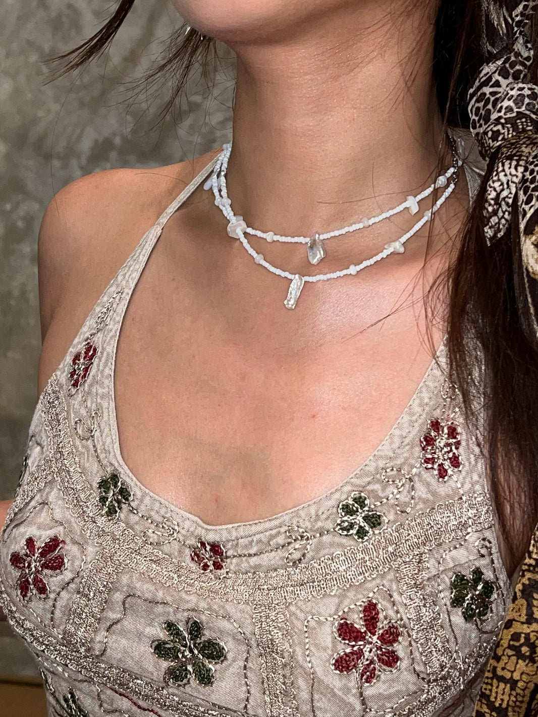 Close up of raw baroque pearl charm and organic shell seed bead strand
