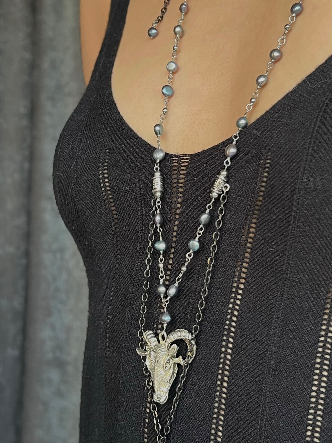 Close-up of vintage silver ram skull pendant with dangling chain fringe tassel