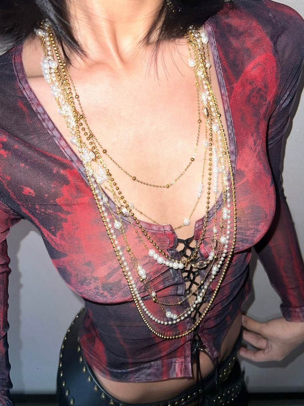 Close-up of cascading gold bead chains and delicate white pearls layers