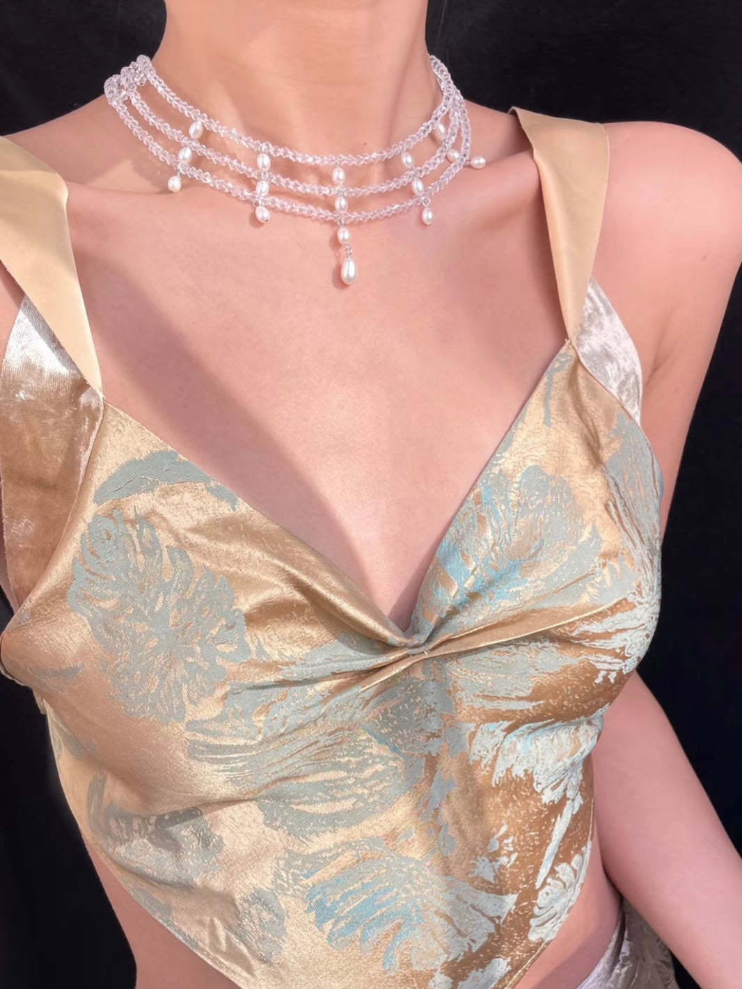 Close-up of clear crystal bead choker with cascading white tear drop pearls