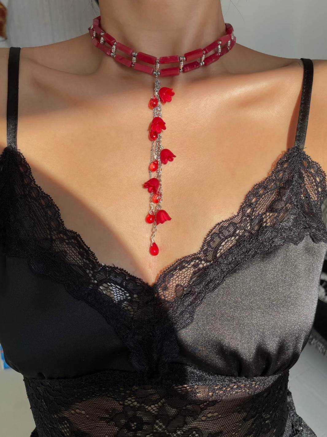 Vibrant red flower pendant glowing under natural sunlight for gothic fairy aesthetic