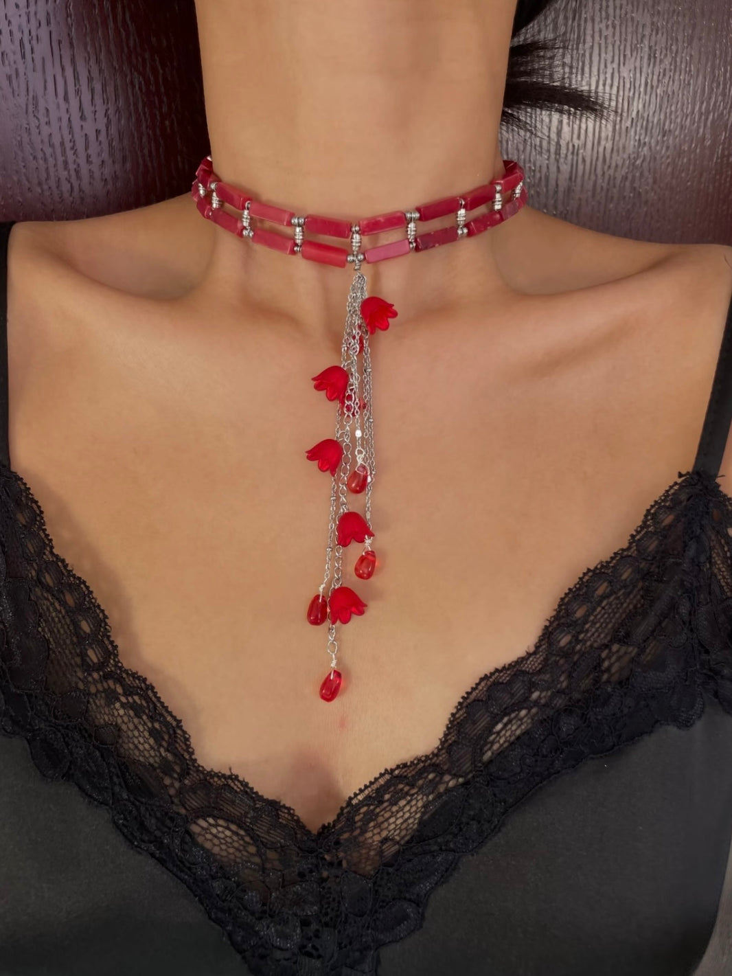 Close-up of crimson red lily of the valley flower pendant with vintage silver chain