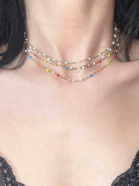 Gleaming multi-way gold chain choker with colorful enameled beads styled on basic top