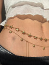 Detailed view of carved gold starfish and shell layered charms gleaming in natural sunlight