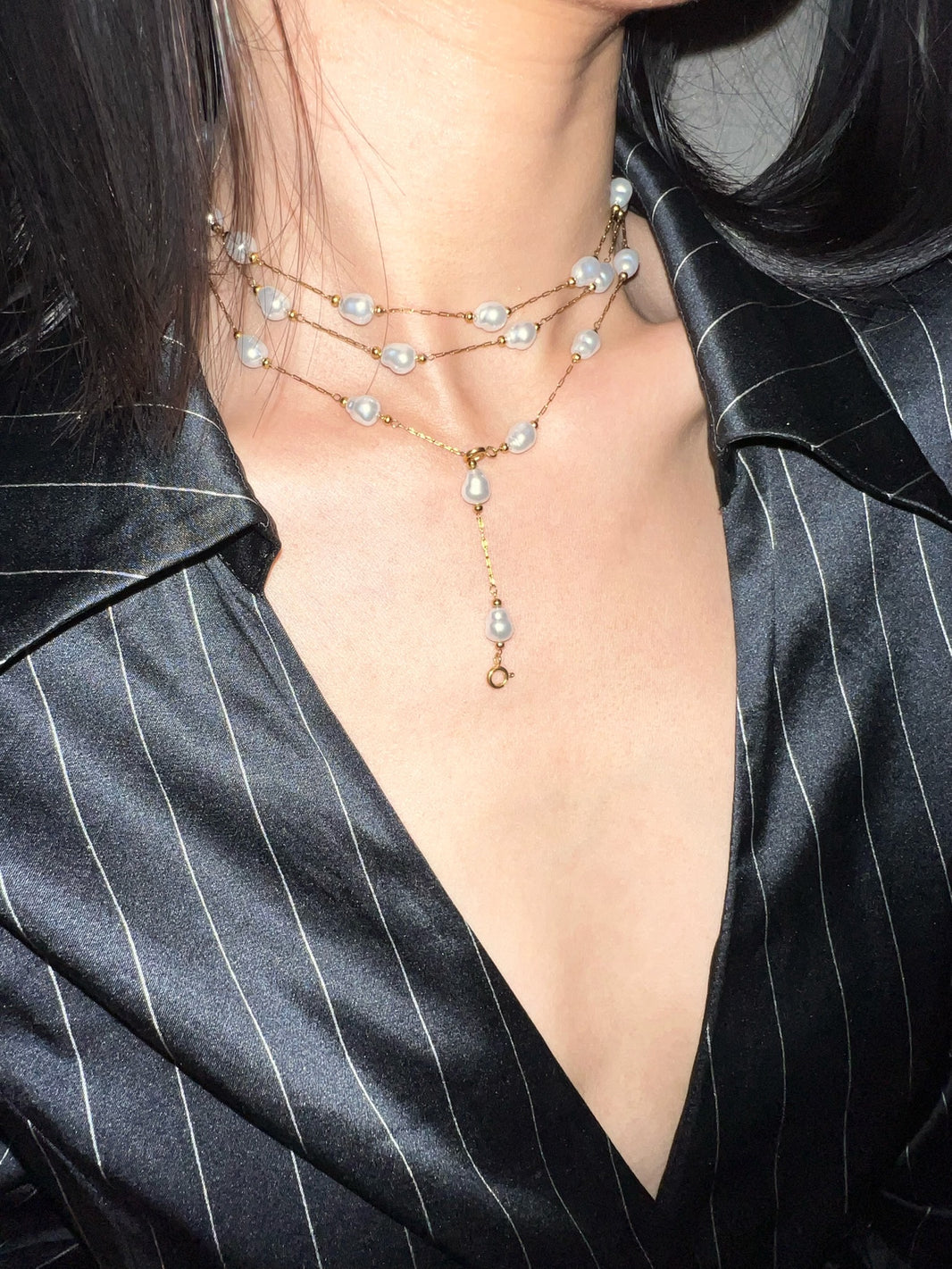 Close-up of gold chain with freshwater baroque pearls, gold beads and dangling pearl tail drop
